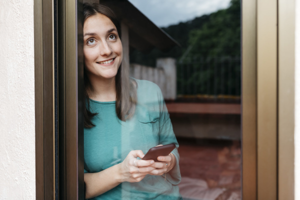 woman using smartphone at window