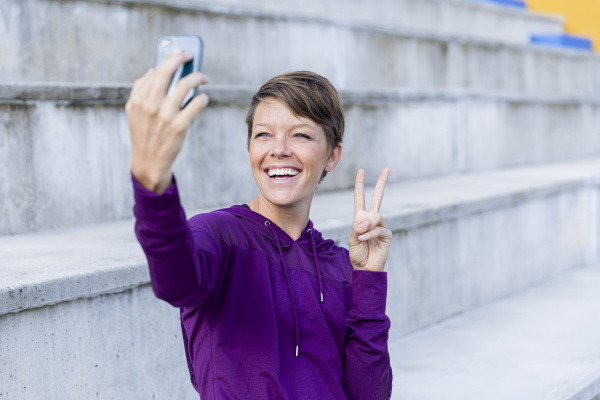 athletic woman using smartphone and taking