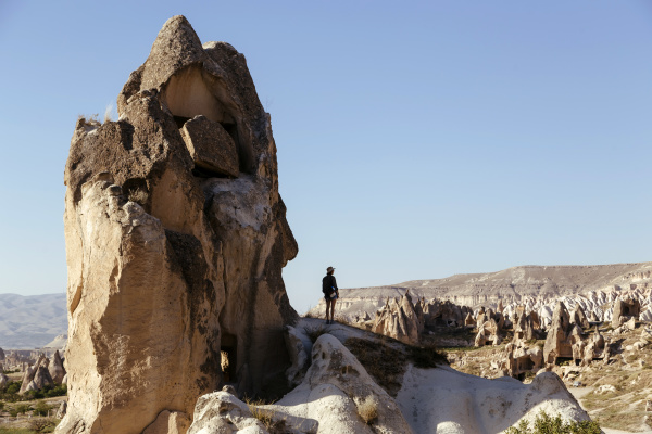 young woman standing on rock formation