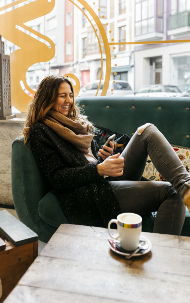 laughing woman using smartphone sitting on