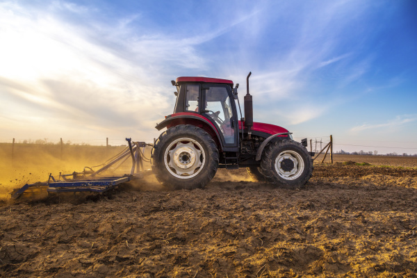 man in tractor plowing agricultural field