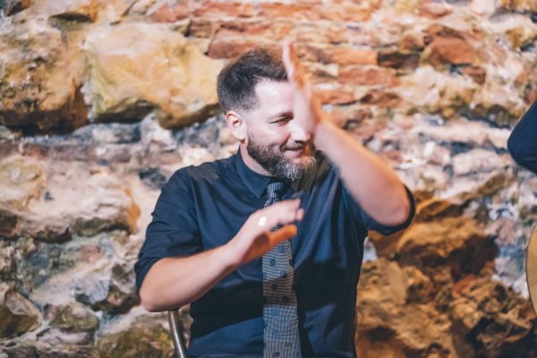 bearded smiling singer clapping hands while