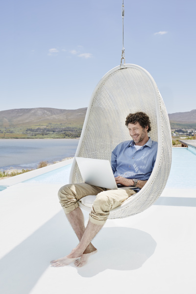 man sitting in hanging chair above