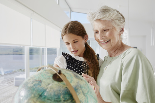 grandmother and granddaughter looking at globe