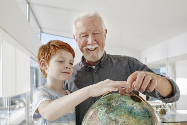 grandfather and grandson looking at globe