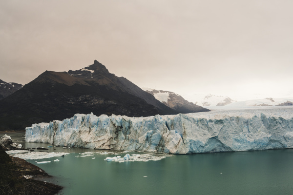 argentina iceberg floating near mountainouscoastline