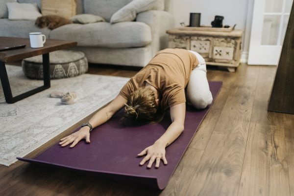 mid adult woman exercising on mat