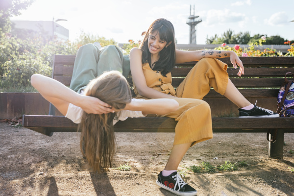 two friends relaxing together on bench