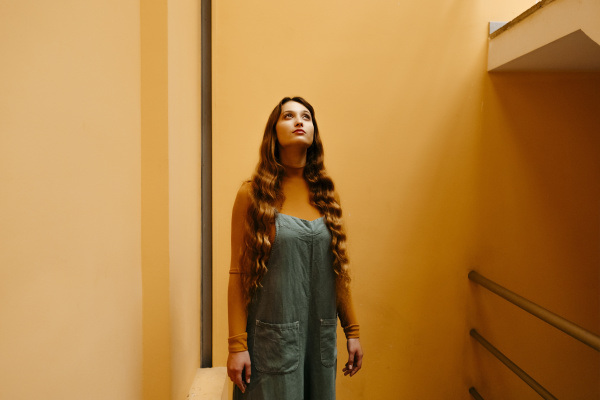 young woman wearing jumpsuit leaning on