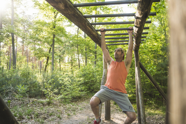 mature man hanging from monkey bars