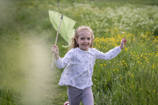smiling girl with butterfly net running