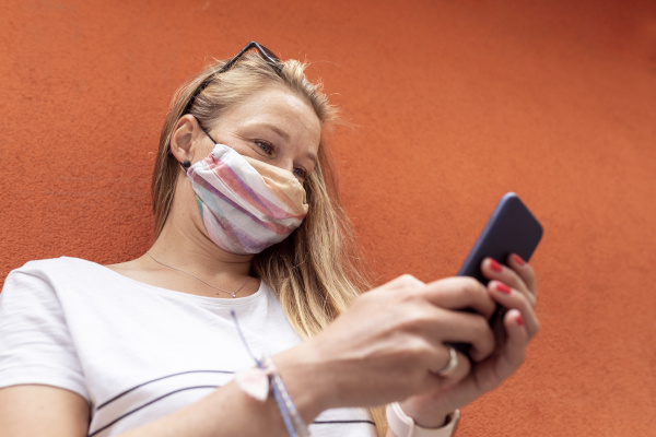 woman wearing mask using smart phone