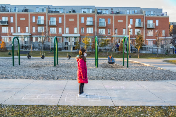 young girl stands at a playground