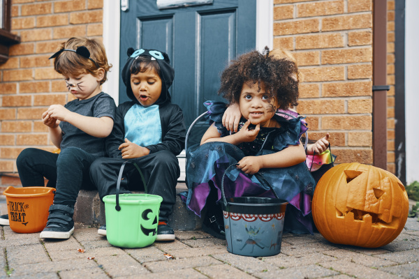 three children dressed for halloween sitting