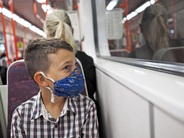 young boy with protective mask travels