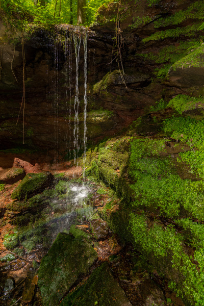 water flowing over moss covered rocks