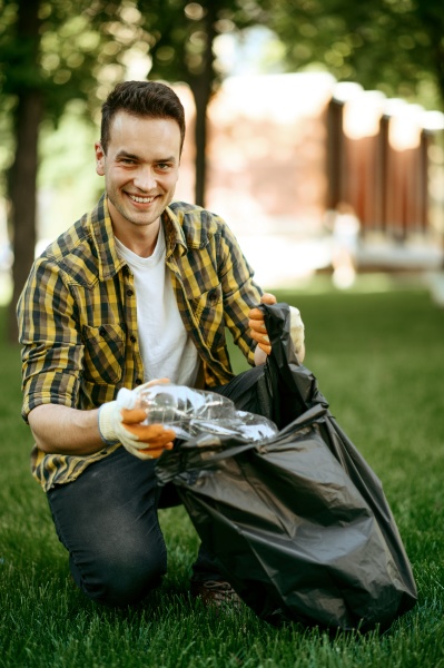 young man collects garbage in a