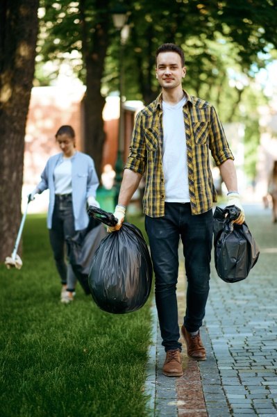 man holds plastic trash bags in