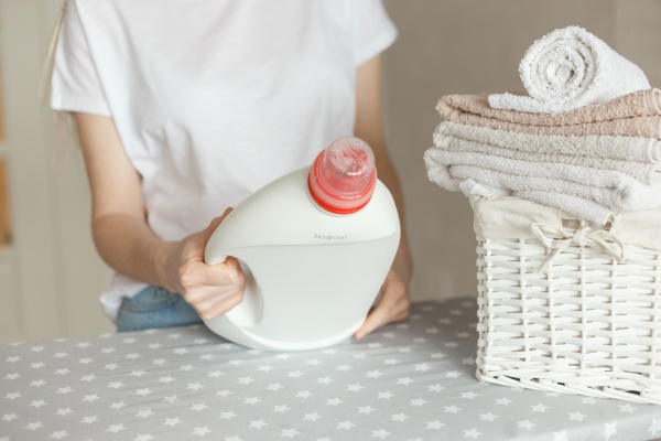 woman holding white bottle with detergent