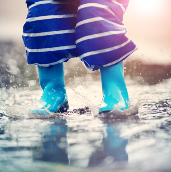 child walking in wellies in puddle