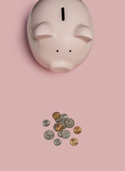 piggy bank and coins on pink