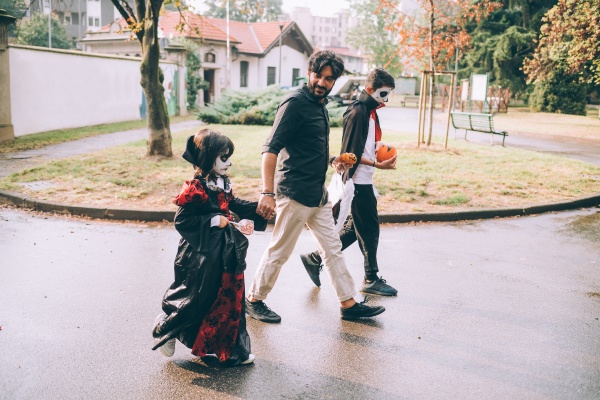 father and children walking in halloween