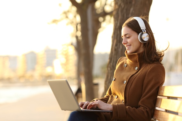 woman wearing headphones using laptop in