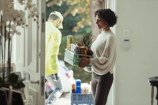 woman receiving grocery delivery from courier