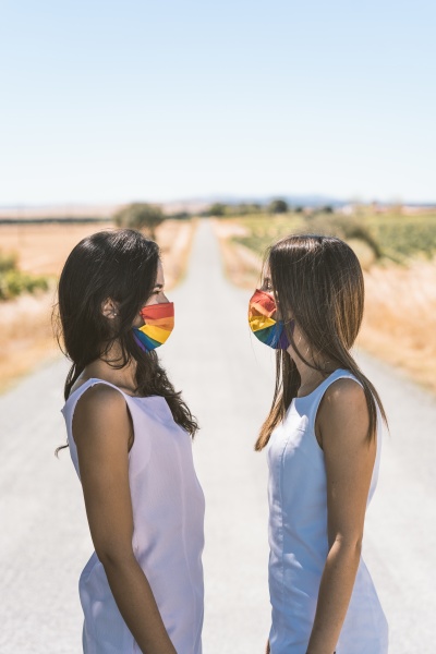 women with rainbow face mask looking