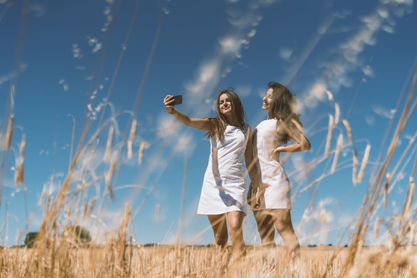 smiling young women taking selfie while