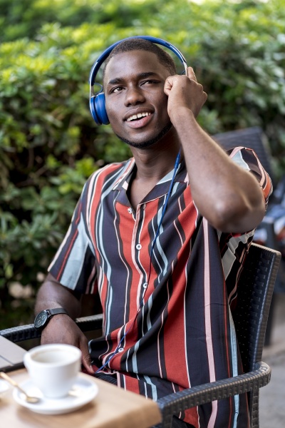 smiling young man listening music on