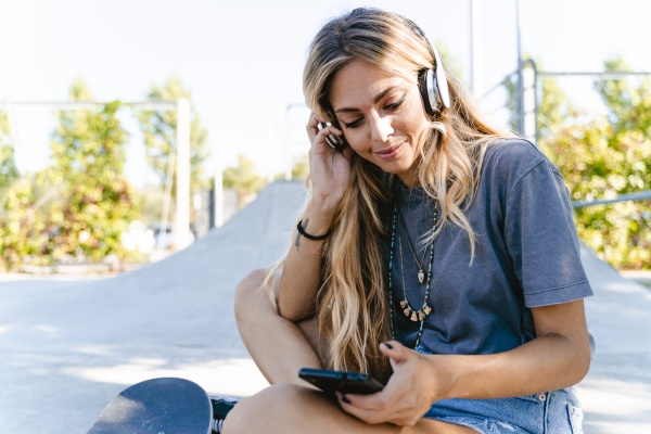 young blond woman listening music through