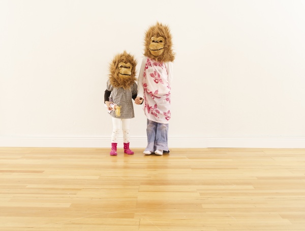 two girls wearing monkey masks standing