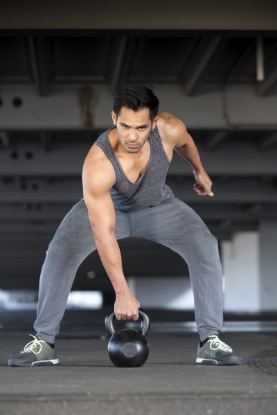 muscular man training with kettlebell