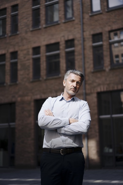 confident businessman with arms crossed standing