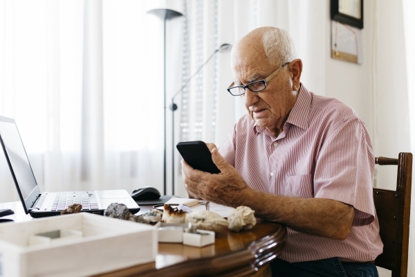 senior man using smart phone while
