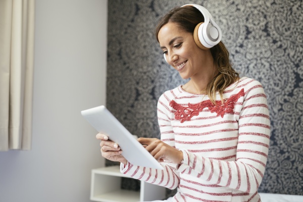 smiling woman listening music over headphones