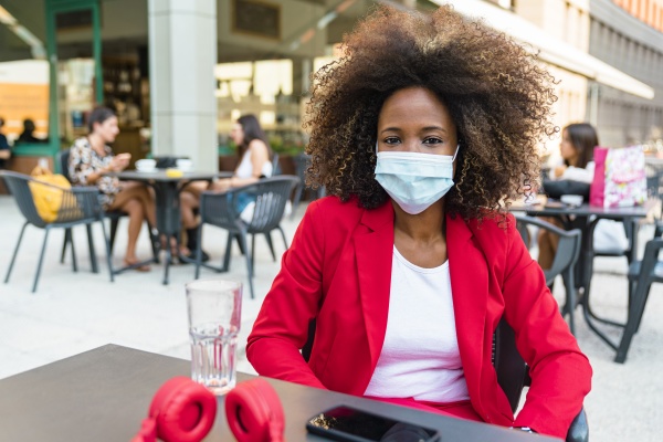 woman wearing protective face mask sitting
