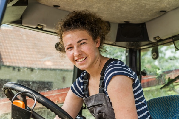 portrait of smiling farmwoman in tractor