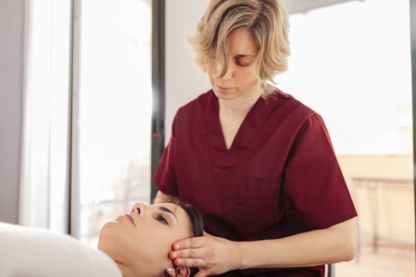 physiotherapist massaging woman head