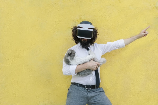 man wearing virtual reality eyeglasses holding