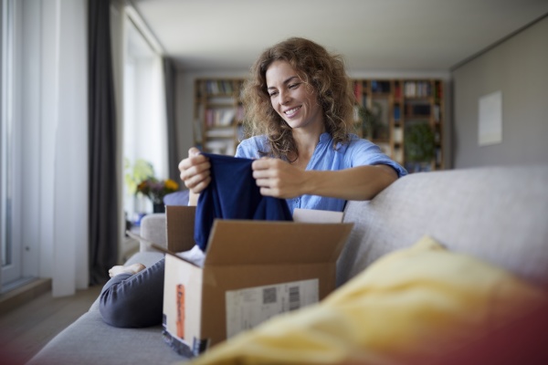 smiling woman removing cloth from package