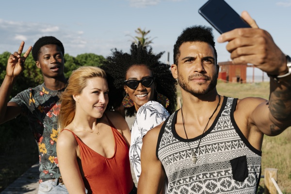 smiling friends taking selfie on smart