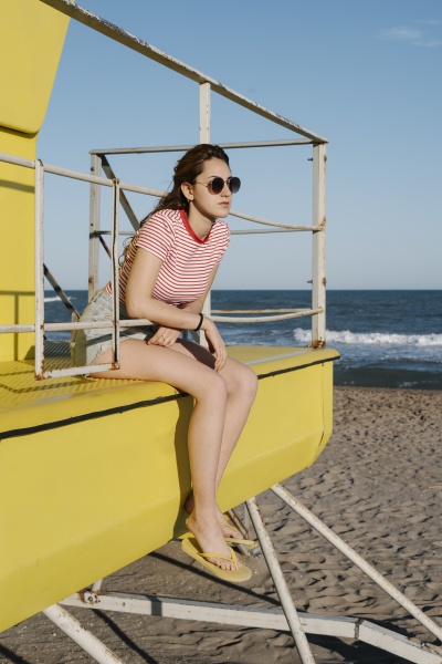 young woman sitting in lifeguard hut