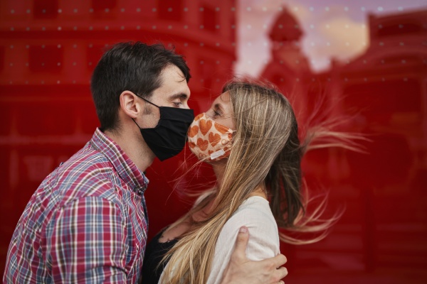 couple kissing with protective face mask