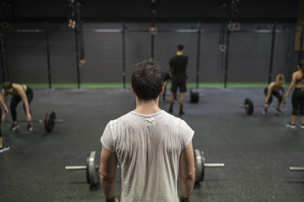 man standing with athletes exercising in