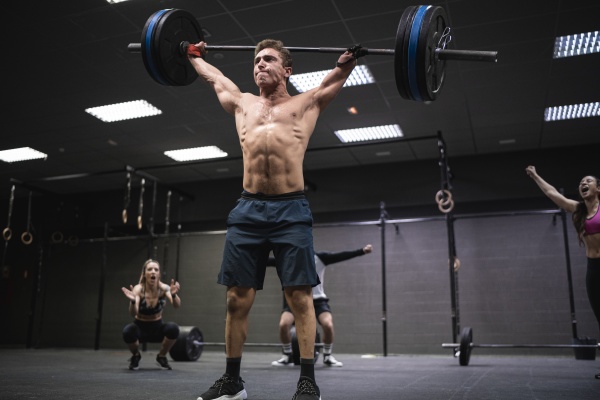 amputee athlete picking barbell with people