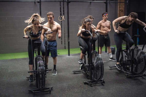 men motivating women exercising on fitness