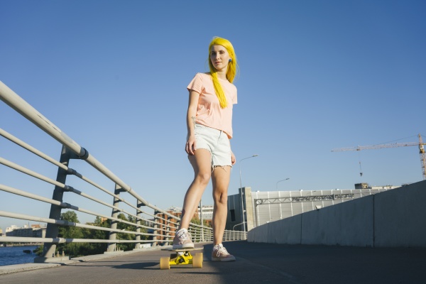 woman standing on skateboard against clear