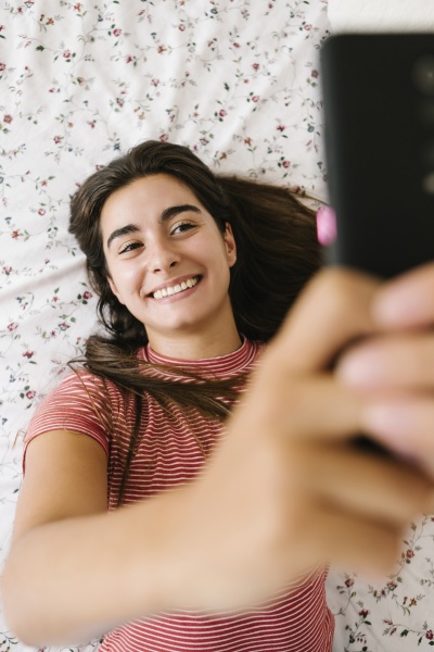 smiling woman taking selfie on smart